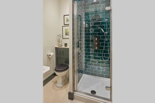a bathroom with a glass shower with a toilet at The Barn in Devizes