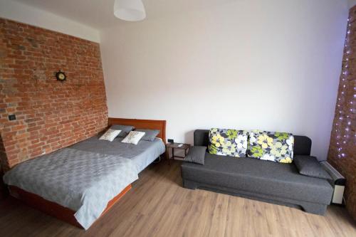 een slaapkamer met een bed en een bank bij Rijeka city rooms in Rijeka