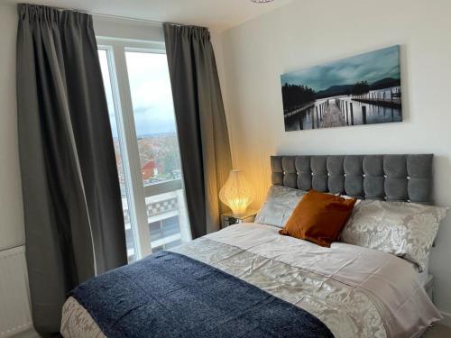 a bedroom with a bed and a large window at Bexleyheath, Regal Walk in Bexleyheath
