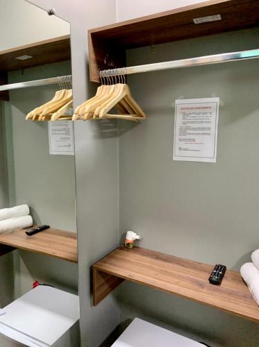 a bathroom with wooden shelves and a toilet at Santa Cecília Pousada in Guarujá