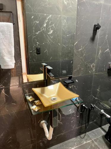 a bathroom with a yellow sink and a mirror at Santa Cecília Pousada in Guarujá