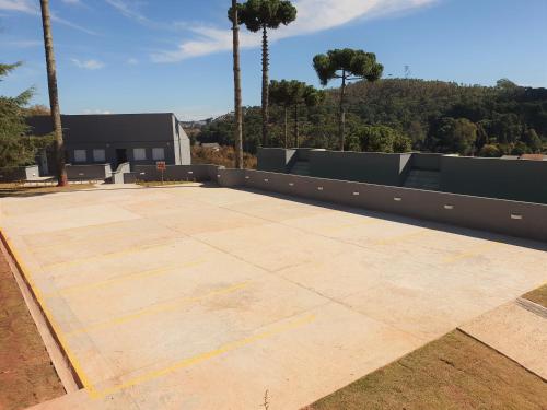 a large concrete patio with palm trees in the background at Winter Garden - Guest House - Campos Do Jordão in Campos do Jordão