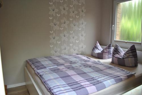 a bedroom with a bed with pillows and a window at Ferienwohnung in Kappeln in Kappeln
