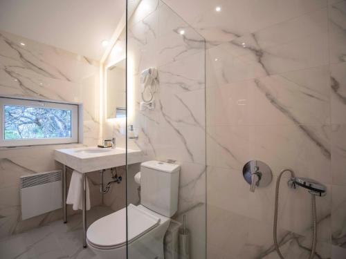 a bathroom with a toilet and a sink and a shower at The Moon Boutique Hotel in Sofia