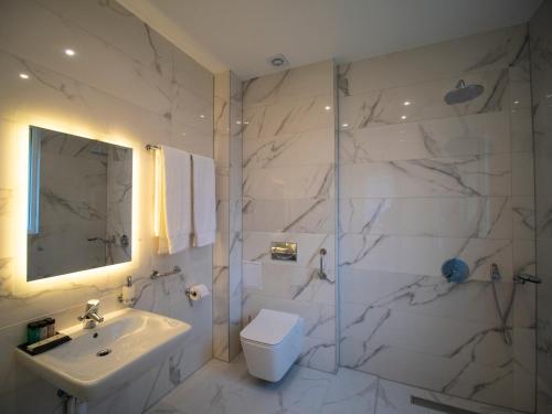 a bathroom with a sink and a toilet and a shower at The Moon Boutique Hotel in Sofia