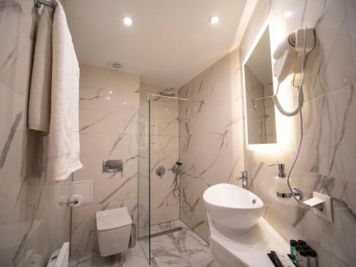 a bathroom with a shower and a toilet and a sink at The Moon Boutique Hotel in Sofia