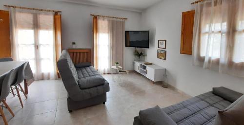 Sala de estar con 2 sofás y TV en VUT Casa Orrios, en el centro de Alcañiz. en Alcañiz