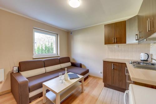 a living room with a couch and a table at Villa Arkodes in Gdańsk