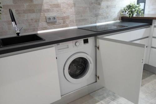 a kitchen with a washing machine under a counter at Loft Bazán - Centro Alicante in Alicante