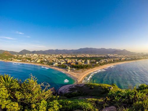 リオデジャネイロにあるRecreio, a praia mais charmosa do RJ!の建物と海を望むビーチの景色を望めます。