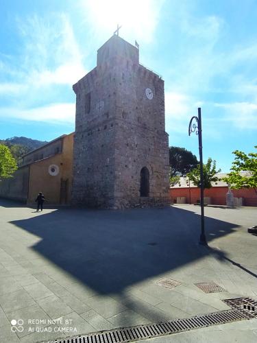 a building with a tower with a clock on it at Ostello ninin de ma' in Framura
