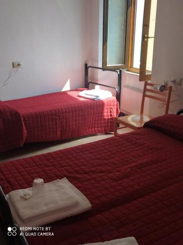a hotel room with two beds with red sheets at Ostello ninin de ma' in Framura
