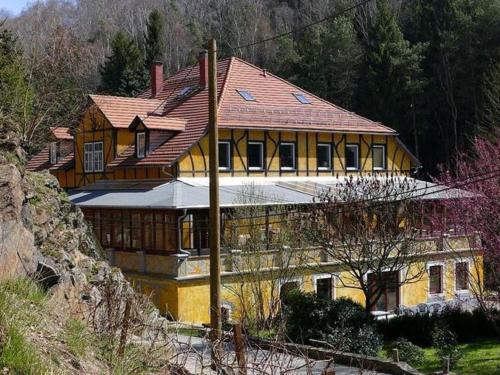 ein großes gelbes Haus auf einem Hügel in der Unterkunft Exclusive apartment in an art nouveau villa in Großschirma