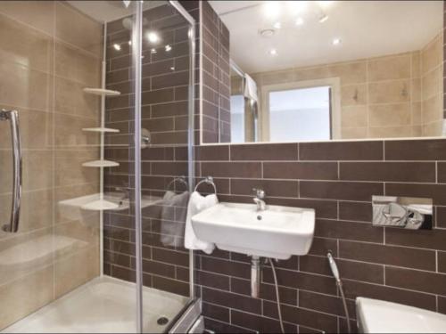 y baño con lavabo y ducha. en Churchill Two Bedroom Apartments with Free Parking and The Minster view, en York