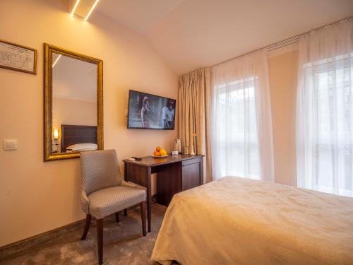 a bedroom with a bed and a mirror and a chair at The Moon Boutique Hotel in Sofia