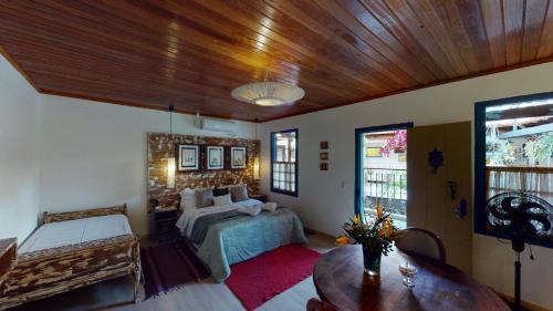a bedroom with a bed and a wooden ceiling at Pousada Quatro Estações in Bichinho