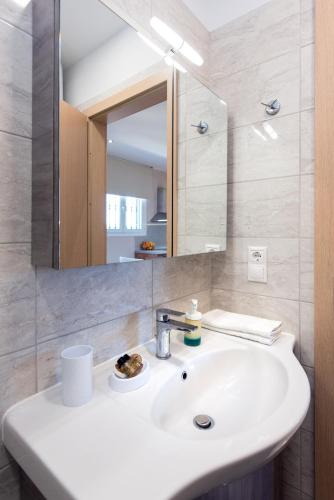 a bathroom with a white sink and a mirror at Lia's Home One in Mantoúkion