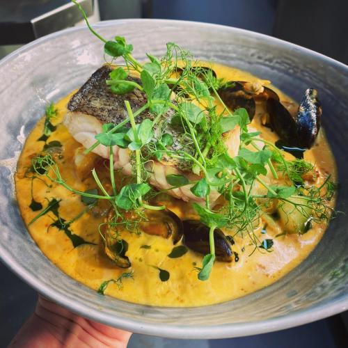 a person holding a bowl of food with a plate of food at Castle Hotel in Eynsford