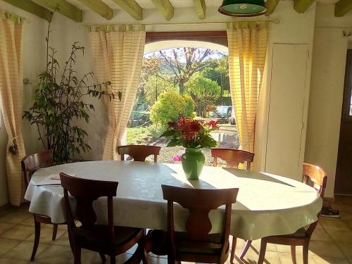 a dining room table with a vase of flowers on it at "Chez Naty" chambres d'hôtes au Pays-Basque in Chéraute