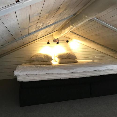 a bed with two pillows and a light on it at Näkna Hill in Åby