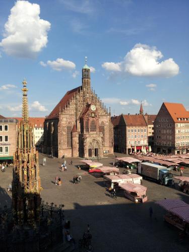 an old building with a clock tower in a city at Sorat Hotel Saxx Nürnberg in Nürnberg