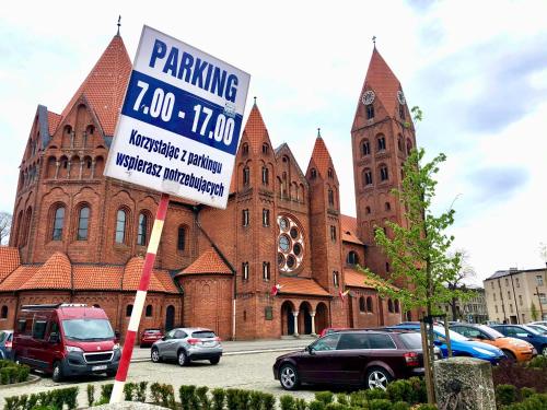 a church with a parking sign in front of it at Stylowy apartament tuż przy Rynku in Ostrów Wielkopolski