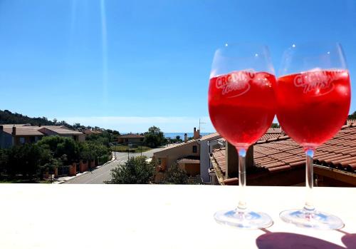 Dos copas de vino tinto en un balcón en Appartamento Alissya en Tortolì
