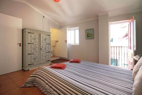 a bedroom with a large bed with red pillows on it at Casa Alentejana in Vila Nova de Milfontes