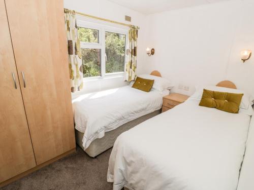 two beds in a room with a window at Alpine Lodge in Abergele