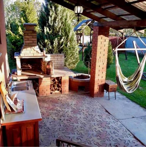 a patio with a grill and a hammock in a backyard at Monica in Yanoshi
