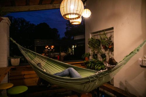 a person laying in a hammock in a room at Pura Vida Mae YerbaBuena in Yerba Buena