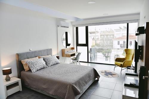 ein Schlafzimmer mit einem Bett und einem großen Fenster in der Unterkunft Zoes Apartment Kos Town in Kos-Stadt
