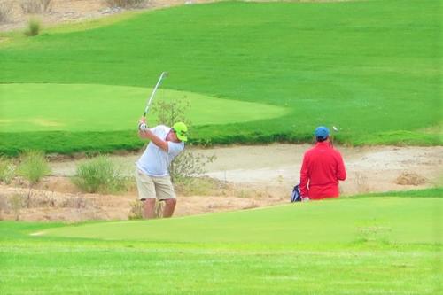a man swinging a golf club on a golf course at Puerto Velero Primera Línea Primer Piso al lado de la Playa! 5 pax in Puerto Velero