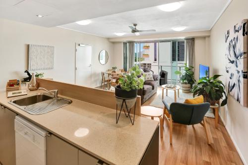 a kitchen and living room with a sink and a table at The Harbour View Condo in Cairns