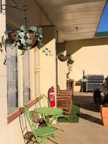 a patio with chairs and a table and a chandelier at ALPINE COUNTRY MOTEL and METRO ROADHOUSE COOMA in Cooma