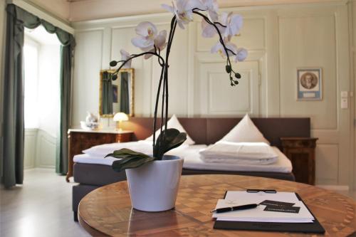 a room with a table with a vase with flowers at Zum Schwarzen Löwen in Altdorf