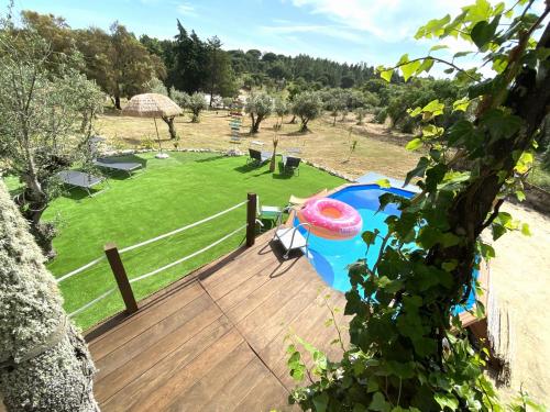 a deck with a umbrella and a field of grass at DoAguaBoa in Coruche