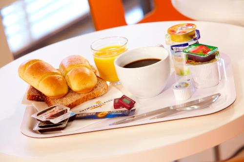 a breakfast tray with bread and coffee on a table at Premiere Classe Dunkerque Est Armbouts Cappel in Armbouts-Cappel