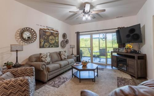 a living room with a couch and a tv at Simple Serenity condo in Branson West
