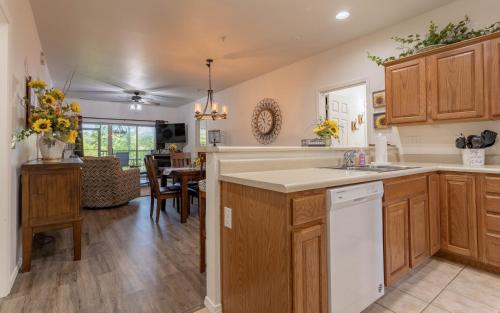 a kitchen with wooden cabinets and a dining room at Simple Serenity condo in Branson West