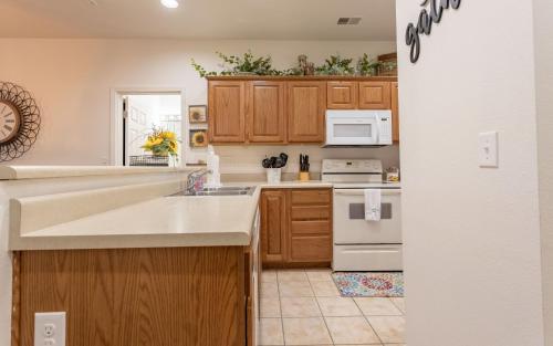 a kitchen with wooden cabinets and white appliances at Simple Serenity condo in Branson West
