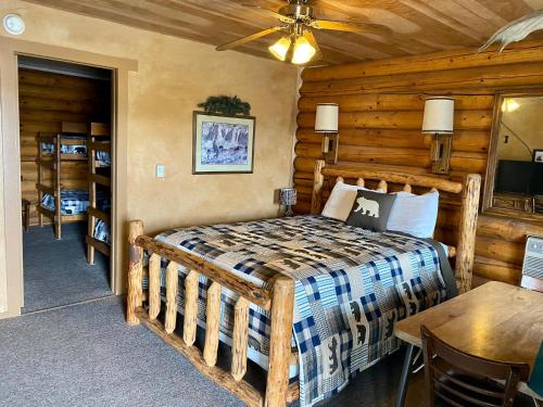 1 dormitorio con 1 cama en una cabaña de madera en Green Creek Inn and RV Park, en Wapiti