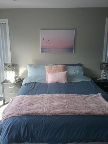 a bed with a blue comforter and birds on it at Best view on Westview in Hanmer Springs