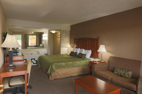 a hotel room with a bed and a couch at Travelers Inn Elizabethton in Elizabethton