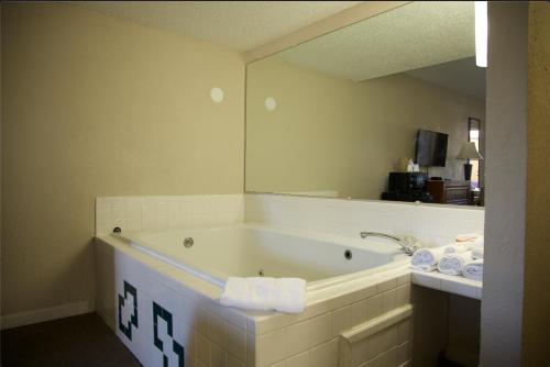 a bathroom with a bath tub with a mirror at Travelers Inn Elizabethton in Elizabethton