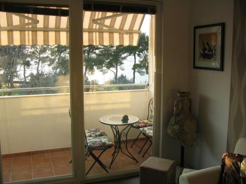 a room with a balcony with a table and a window at Apartment Oliva in Fažana