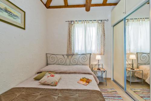 a bedroom with a bed with two lamps and two windows at Villa Dubrovnik Chalets in Močići