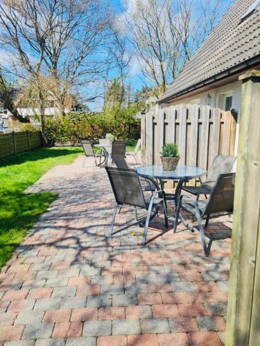 a patio with a table and chairs and a fence at Strandapartment in Westerland für 2-4 Personen in Westerland (Sylt)