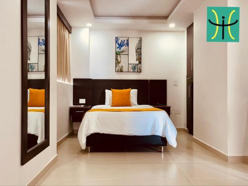 a bedroom with a bed with orange and white sheets at Hotel Interpacific in Quibdó