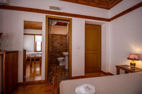 a living room with a bed and a bathroom at Hotel Bebej Tradicional in Gjirokastër